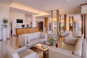 安科纳NH安科纳酒店的带沙发和桌子的客厅以及电视。