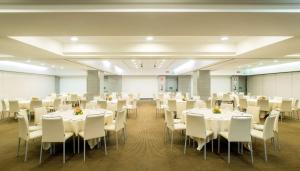 塞格拉泰NH米兰2酒店的宴会厅配有白色的桌子和白色的椅子