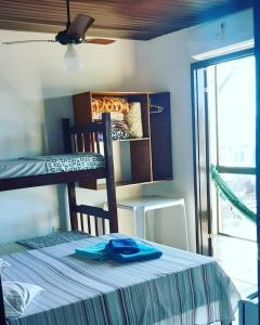 卡拉瓜塔图巴Pousada Marambaia的一间卧室配有一张双层床,桌子上摆放着蓝色衬衫