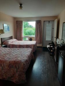 沃德勒伊多里翁Motel Vaudreuil的酒店客房设有两张床和窗户。