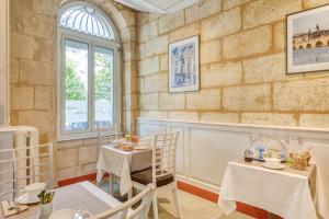 波尔多Hôtel des Voyageurs Centre Bastide的一间设有两张桌子和窗户的用餐室