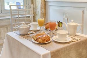 波尔多Hôtel des Voyageurs Centre Bastide的一张桌子,早餐包括羊角面包和橙汁
