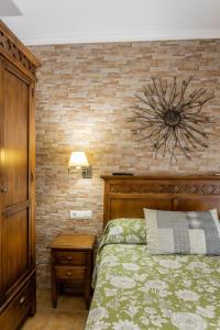 圣玛丽亚港客斯露旅馆 的一间卧室设有一张床和砖墙