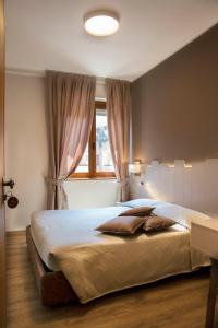 波里奥特米米兰酒店的一间卧室设有一张大床和窗户