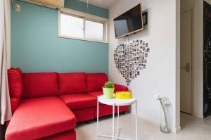 福冈City Garden - Vacation STAY 87278的客厅配有红色沙发和心墙