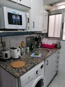 瓦伦西亚PISO EN MALVARROSA的厨房配有洗衣机和微波炉。