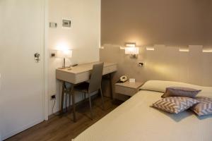 波里奥特米米兰酒店的一间卧室配有一张床、一张桌子和一张桌子