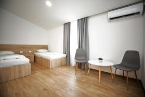 默主歌耶APARTMANI M&J Međugorje的一间卧室配有两张床和一张桌子及椅子