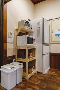 松本Couch Potato Hostel - Vacation STAY 88243的厨房配有冰箱和微波炉,位于架子上