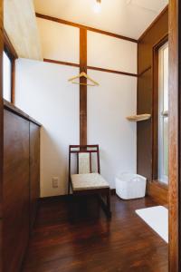松本Couch Potato Hostel - Vacation STAY 88243的客房设有椅子和吊扇。