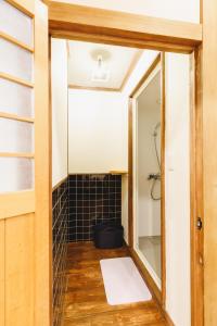 松本Couch Potato Hostel - Vacation STAY 88243的浴室设有镜子和黑色瓷砖淋浴。
