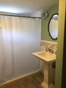 伍兹霍尔时光之沙汽车旅馆和海港大厦的浴室配有淋浴帘和盥洗盆。