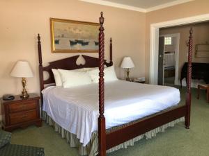伍兹霍尔时光之沙汽车旅馆和海港大厦的一间卧室配有一张木架大床