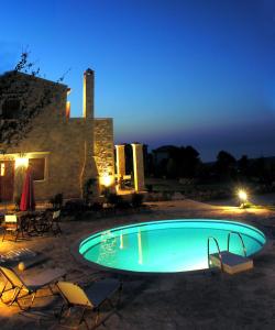 圣特里亚斯Cretan Exclusive Villas的夜间在房子前面的游泳池