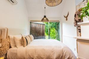 棕榈滩Boho Hill Waiheke Island的一间卧室设有一张大床和一个窗户。