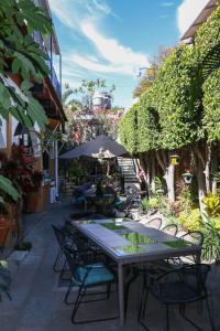 瓦哈卡市Las Mariposas Hotel & Studios的庭院里配有桌椅和遮阳伞