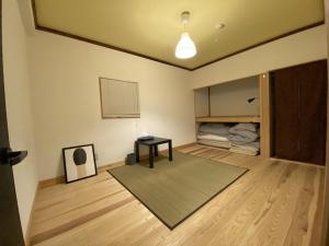 会津若松mooi guesthouse 日新町的客厅配有桌子和床。