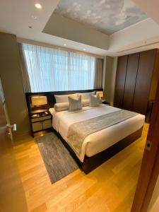 东京东京丸之内雅诗阁服务公寓酒店的一间卧室设有一张大床和一个大窗户