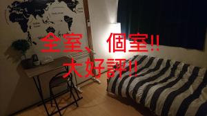 堺市UNLOCK SAKAI的一间卧室配有一张床、一张桌子和一张书桌