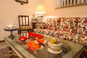 锡耶纳三姑娘酒店的客厅配有沙发和鲜花桌