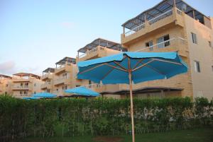 阿莱曼Badr Deluxe Apartments - Families Only的大楼前的蓝伞