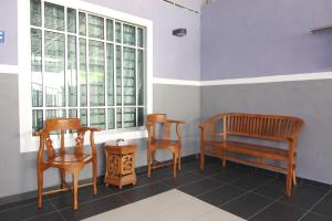 巴力拉惹Homestay Hj Esmon 3 UTHM Parit Raja的窗户的房间里设有两把椅子和一张长凳