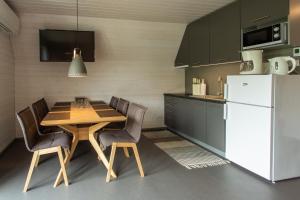 基维厄利Tuhamäe hosteli puhkemaja的厨房配有木桌和白色冰箱。