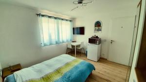 DonatyreChambre d'hôte "Minergy"的一间卧室配有一张床和一张带微波炉的桌子。