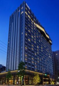 横滨横滨凯悦酒店的一座高大的建筑,旁边灯火通明