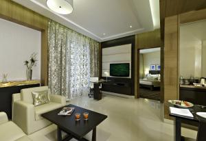 孟买梅鲁哈费恩酒店的带沙发、桌子和电视的客厅