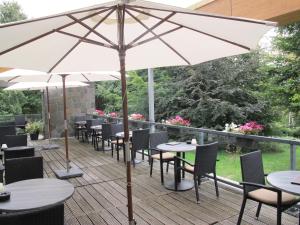 贝亨奥普佐姆Fletcher Wellness-Hotel Stadspark的一个带桌椅和遮阳伞的庭院