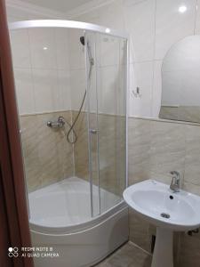 卡拉甘达Nuri Hotel Стадион的水槽旁的玻璃门淋浴