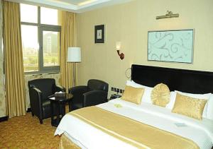 利雅德Continent Al Waha Hotel Riyad的酒店客房带一张大床和椅子