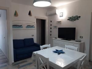 阿列恩图Appartamento Residence Mirice Vignola mare Aglientu casa Giorgia的客厅配有白色桌子和蓝色沙发