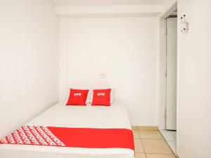 圣保罗OYO Hotel Vintage, São Paulo的一张床位,房间配有两个红色枕头