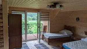 艾兹基Gostynna Rodyna的客房设有一张床和一个带窗户的阳台