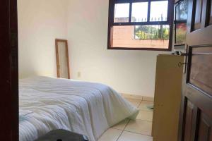 阿蒂巴亚Casinha de Campo bem localizada的一间卧室设有一张床和一个窗口