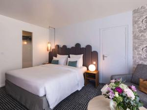 艾克斯莱班Mercure Aix-les-Bains Domaine de Marlioz Hôtel & Spa的酒店客房设有一张大床和一张沙发。