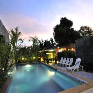 查龙Serene Villa Phuket的一个带椅子的游泳池以及一座房子