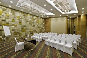 孟买梅鲁哈费恩酒店的一间会议室,配有白色椅子和讲台