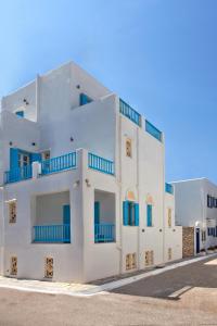 提诺斯TINOS AQUA PALAZZO的白色的建筑,设有蓝色的阳台,位于街道上