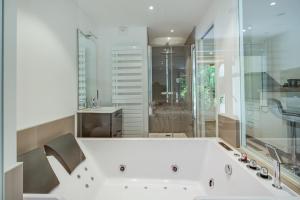 BoerschWellholidays 19 - studio balnéo et terrasse piscine的浴室配有白色浴缸及水槽