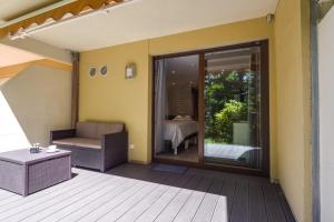 BoerschWellholidays 19 - studio balnéo et terrasse piscine的客房设有一个带沙发和桌子的庭院。