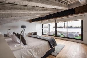 瓦伦西亚Mon Suites San Martin的一间卧室设有一张大床和一个大窗户