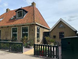 HunsVakantiehuis in Friesland voor de hele familie的前面有围栏的房子