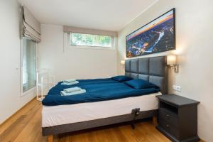 塔尔图Gustav Apartments - City Center Comfort的一间卧室配有一张带蓝色床单的大床