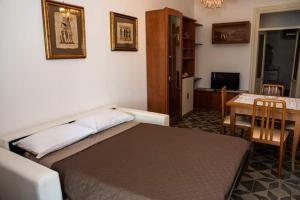 洛科罗通多Belvedere的一间卧室配有一张床铺和一张桌子,还有一间用餐室