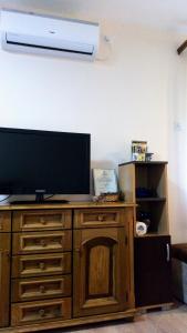 皮罗特Guest House Green view的木质梳妆台上的电视,配有一台平面电视