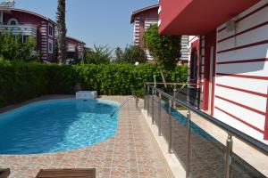 贝莱克Antalya belek private villa private pool 4 bedrooms close to beach park - land of legends的一座游泳池,位于一座建筑旁的院子内