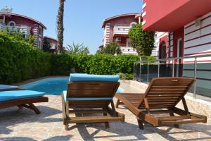贝莱克Antalya belek private villa private pool 4 bedrooms close to beach park - land of legends的游泳池畔的两把椅子和一张桌子
